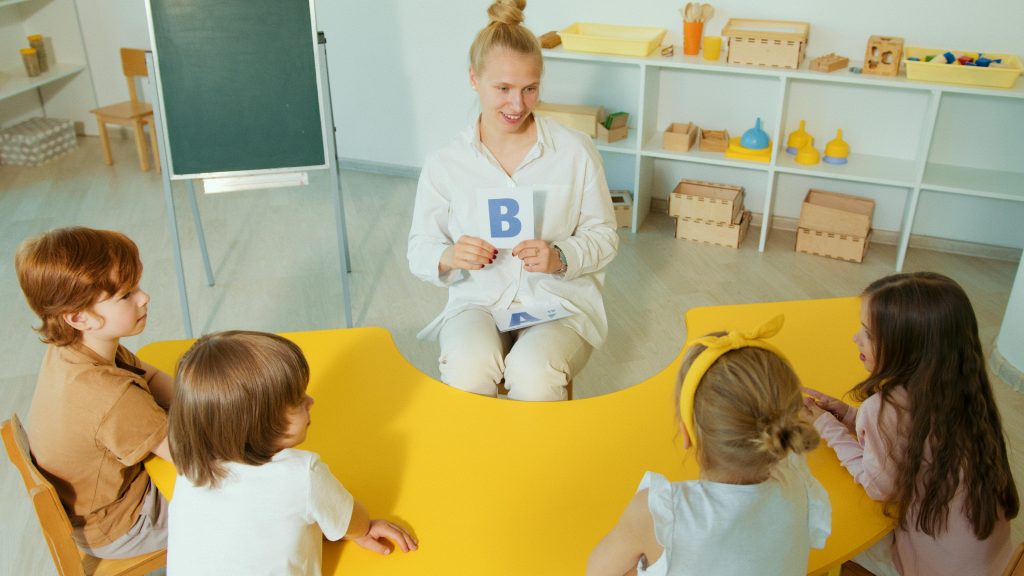 pexels-photo-8087857-8087857 Teacher with children learning the alphabet in a vibrant classroom.